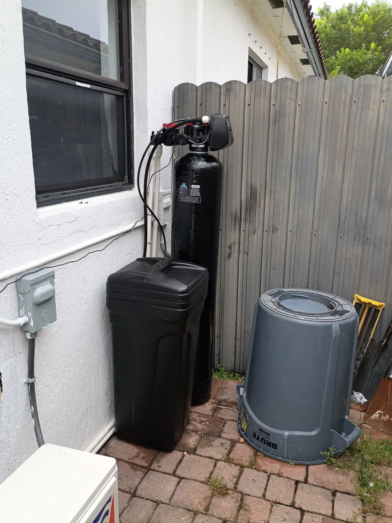 Whole-home water treatment system installed beside a home